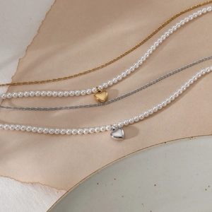 Set of layered pearl necklaces with gold and silver heart pendants on elegant display