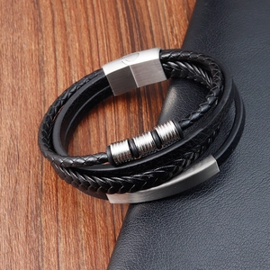 Detail of multi-layer braided leather bracelet with silver beads on rustic wood