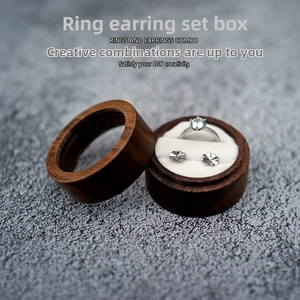Macro view of walnut wood jewelry box with clear window and silver ring earring set