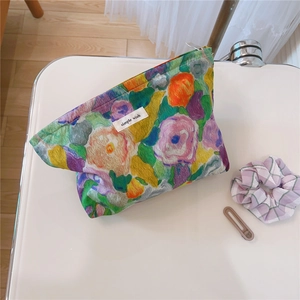 Detail of floral makeup bag featuring an impressionist oil painting print and zipper