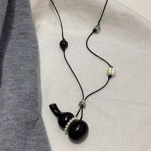 Vintage wood gourd pendant necklace with pearls on black cord, over sweater chain