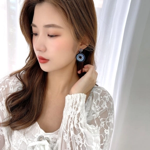 Bohemian round earrings with blue bead gradients worn by a model in natural light