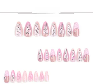 Vue détaillée de faux ongles amande avec nœuds argentés 3D et perles roses