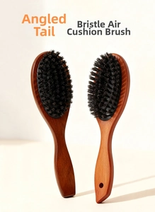 Close-up of wooden boar bristle hairbrush with ergonomic handle and soft air cushion