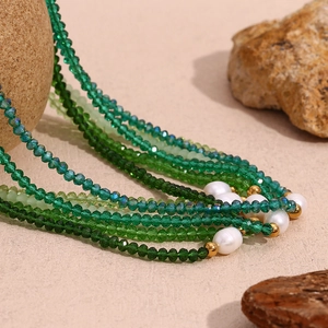 Detailed macro view of green crystal beads and white pearls on a beaded necklace