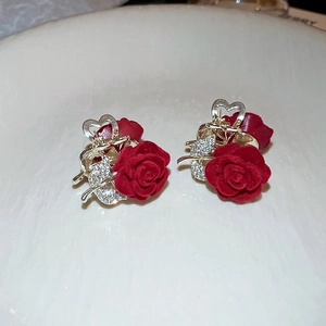 Detailed macro view of red flocked rose hair clips with sparkly crystals and gold base