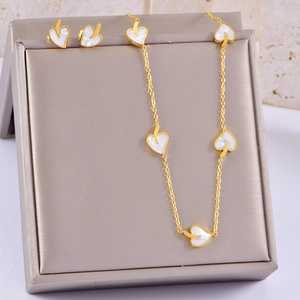Close-up of golden leaf jewelry set with white shell inlay on a premium display box