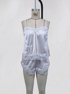 Detailansicht eines rosa Satin-Schlafanzugs mit weißem Spitzenbesatz und Schleife