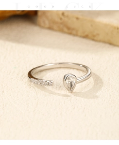 Macro detail of S925 sterling silver ring with pear-cut cubic zirconia and open band