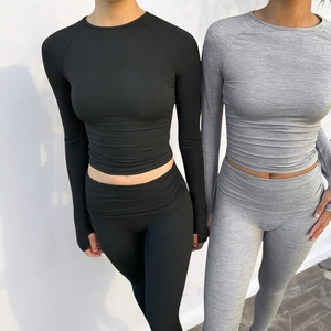 Detail of high-stretch yoga set featuring long sleeve raglan crop top and leggings