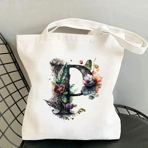 Canvas tote bag featuring floral letter P print on a stylish black iron chair