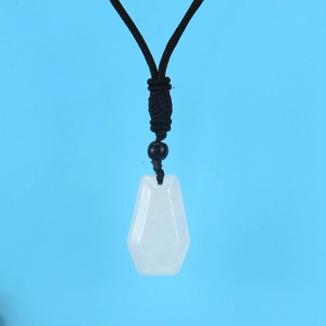 Macro view of white translucent geometric stone pendant with black woven rope