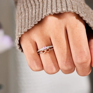 Macro shot of S925 silver ring set with pink heart stone and rose gold infinity symbol