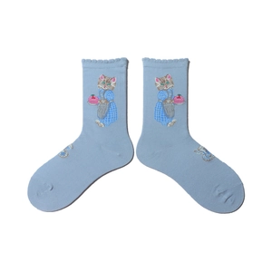 Detail of light blue knit socks featuring cute cat embroidery and ruffled cuffs