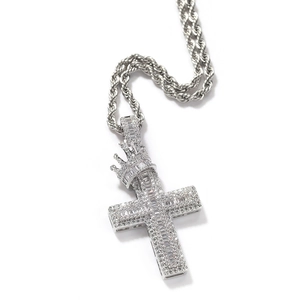 Close-up of silver crown cross pendant with cubic zirconia on a rope chain necklace