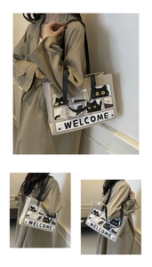 Three-way view of a canvas cat tote bag with Welcome print on a khaki trench coat