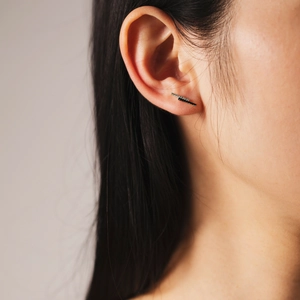 Close-up of minimalist S925 sterling silver bar earring with zircon inlays on model