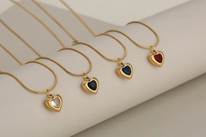 Detail of four colorful heart crystal pendants on gold snake chain necklaces