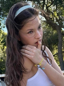 Outdoor shot of a light blue acetate headband and colorful beaded bracelets on a woman