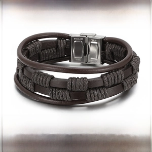 Detail of multi-layer braided leather bracelet featuring engraved stainless steel clasp