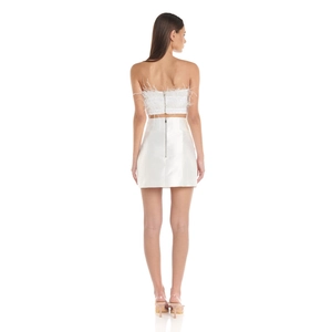 Detail of white ostrich feather top and satin mini skirt showing back texture and fit
