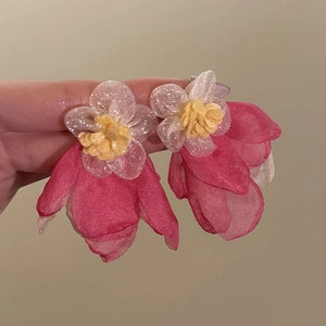 Close-up of pink and yellow organza flower tassel earrings with shimmering silver needle pins