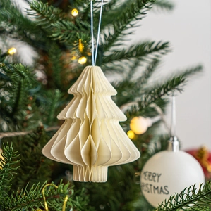 Detail of cream honeycomb paper Christmas tree ornament hanging on a festive branch