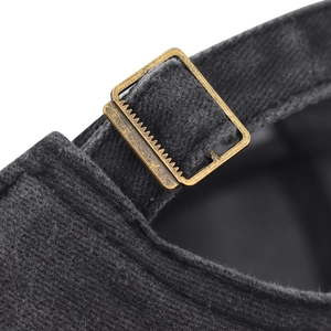 Détail macro de la boucle en métal bronze sur une casquette de baseball grise délavée