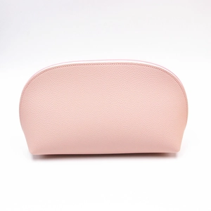 Detail of light pink lychee pattern PU leather texture on a semi-circular makeup bag