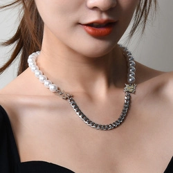 Detail of necklace featuring white pearls and silver Cuban chain with star metal charms