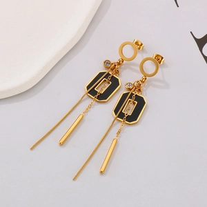 Gros plan de boucles d'oreilles à pompon plaquées or avec émail noir et zircons