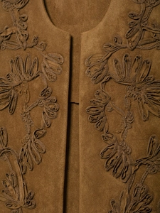 Detail of brown faux suede vest featuring intricate 3D floral embroidery and rich texture