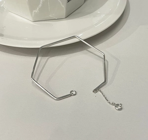 Detail of minimalist silver hexagonal bangle with adjustable chain and spring clasp