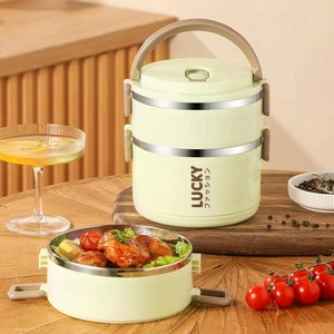 Detail of light green double-layer lunch box with stainless steel interior and roast chicken