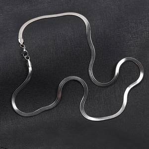 Detail view of a 4mm silver flat snake chain necklace with lobster clasp on grey fabric