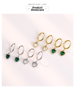 Détail de boucles d'oreilles créoles en acier avec zircon en forme de cœur