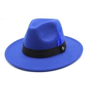 Détail du chapeau Fedora bleu royal en laine avec ruban noir, plume et logo métallique doré