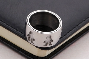 Detailed macro view of silver steel ring featuring hollow boy and girl silhouette patterns