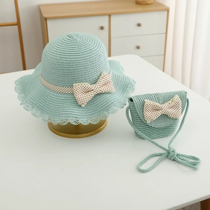 Close-up of mint green straw hat and matching bag set with lace and bow details