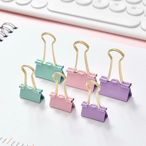 Pastel binder clips set in mint, pink, and purple colors on a white notebook desk