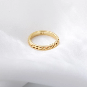 Detail of s925 silver gold-plated twisted ring showing 925 hallmark on white silk