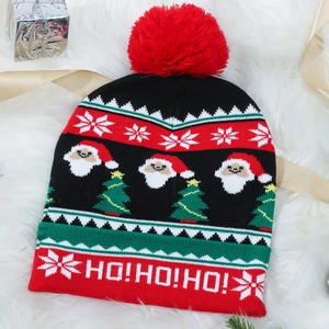 Detail of Christmas knit hat with HO!HO!HO! text on red brim and santa pattern