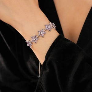 Details des verstellbaren Armbands mit violetten Zirkonia-Blüten am Handgelenk des Modells