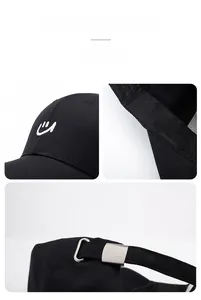 Detail of black cotton baseball cap with white smile embroidery and adjustable metal buckle