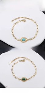Detailed macro view of 18K gold-plated stainless steel chain with oval turquoise stone
