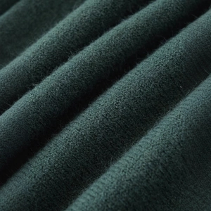 Close-up of soft dark green knit sweater fabric texture with fine vertical ribbed details