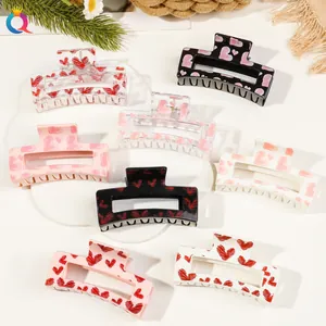 Macro shot of 8-pack large square hair claws with printed heart patterns in a white tray