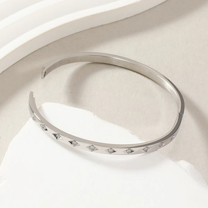 Polished silver titanium steel bangle featuring ten sparkling diamonds on stone base
