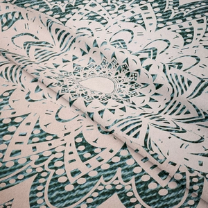 Gros plan d'un motif mandala sur une tapisserie bohème tissée aux accents de sarcelle
