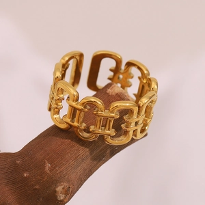 Macro shot of gold-plated stainless steel hollow chain ring on textured wood background